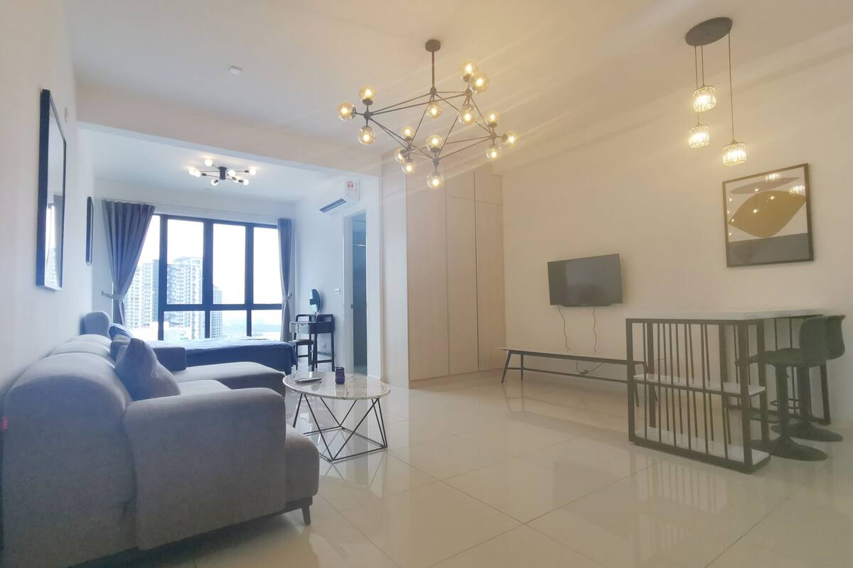 Un salon moderne avec un canapé, une table basse et un téléviseur fixé au mur.
