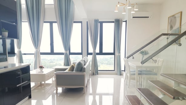 A modern living room with a sofa, a TV, and a staircase. - The Elysia Park Residence (Iskandar Puteri)