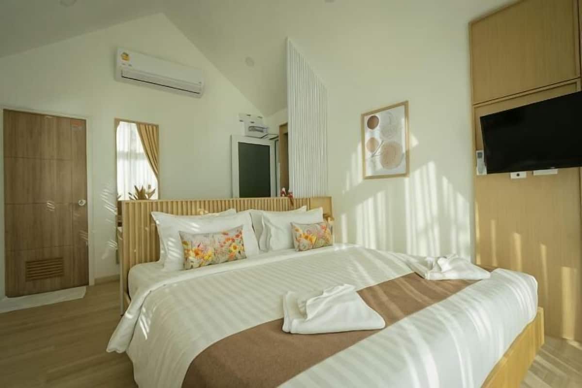 Une chambre avec un lit, une télévision, un appareil de climatisation et une armoire.