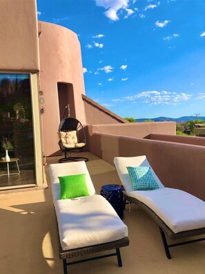 Relax in style with two comfortable lounge chairs and a serene view of the surrounding landscape.