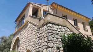 Un edificio de piedra con un balcón y una ventana pequeña.