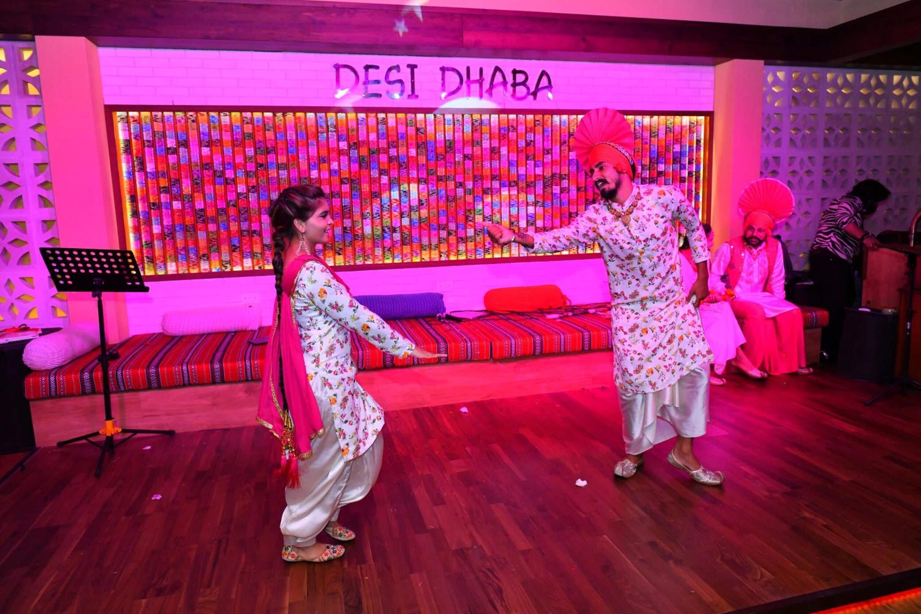 Un escenario con un fondo colorido y un letrero que dice 'DESI DHABA'.