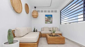 Ein stilvolles Wohnzimmer mit einer Couch, einem Couchtisch und einer Topfpflanze.