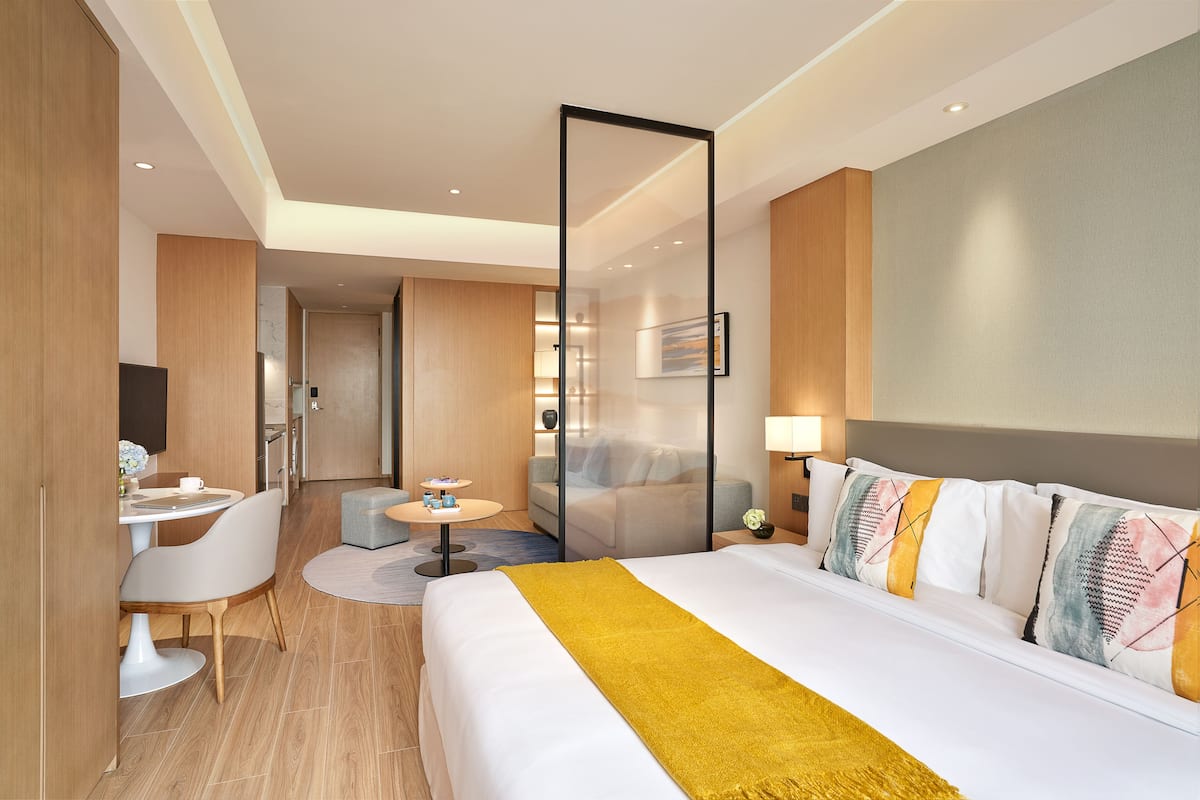 Une chambre d’hôtel comprenant un lit, un bureau, une chaise, un canapé et une petite table.