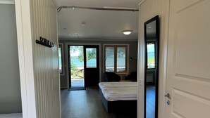 A hotel room with a bed, a desk, and a view of the outdoors. - Gröna Uddens Camping (Mariehamn)