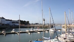 A marina with multiple boats docked, a lighthouse, and a building with a white facade. - Rendezvous with the Sea - Mobilhome Vue Mer Conguel 4* (Conguel sea view mobile home) (Quiberon)