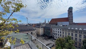 Un paisaje urbano con edificios históricos, una destacada torre del reloj y cielo despejado.