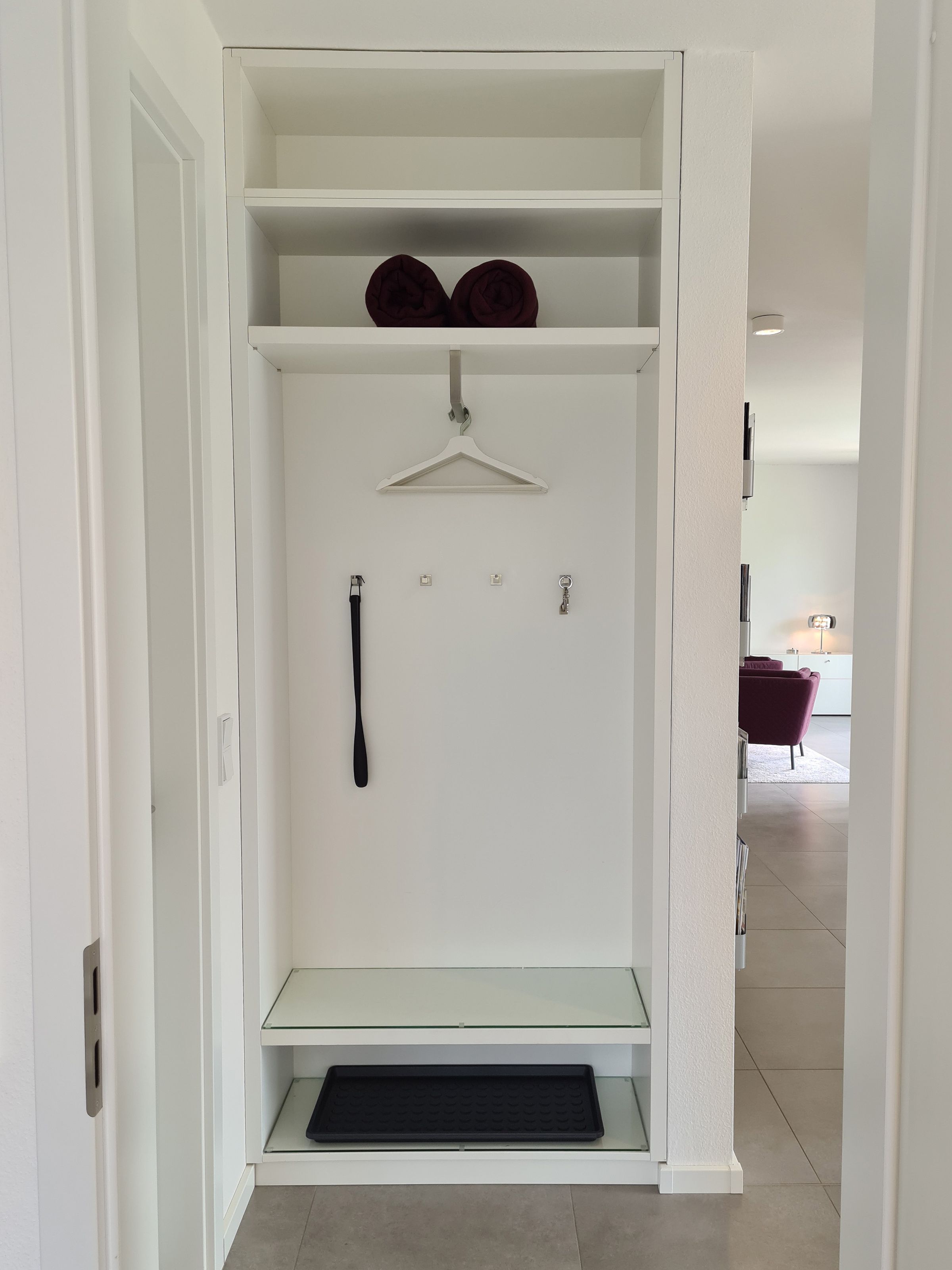 Un vestidor con barra para colgar, estantes y un zapatero.