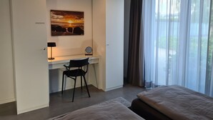 A hotel room with a desk, chair, and two beds. - Eilers, Katja Lilly, Ferienwohnung Lilly - Ferienwohnung Lilly (Varel)