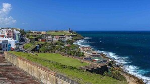 Une ville côtière dotée d’un fort, de bâtiments le long de la côte et offrant une vue sur l’océan.