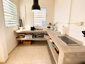 A modern kitchen with a built-in stove, a microwave, and a sink.