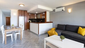 Une cuisine moderne avec des meubles en bois, un îlot central et un coin repas comprenant une table et des chaises.