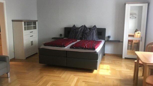A bedroom with a bed, a dresser, a chair, and a table. - "elise" Apartments Nr.1 2019 Hochwertig Eingerichtetes Apartment (Mücheln (Geiseltal))