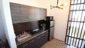 A compact kitchen with a sink, dark cabinets, a microwave, and a patterned floor. - A2-Quaint 1B-Fast WiFi-Walk to Restaurants, Beach (San Juan)
