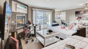 A hotel room with a bed, a desk, a chair, a crib, and a balcony with a view. - Amazing Family Friendly Newport Beach Home - 1 Block To Ocean (C2) (Newport Beach)