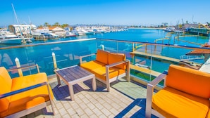 A marina with boats, a pool, and orange lounge chairs. - Amazing Family Friendly Newport Beach Home - 1 Block To Ocean (C2) (Newport Beach)