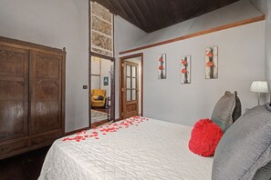 Ein Schlafzimmer mit einem großen Bett, einem Holzschrank und einer Tür zu einem anderen Raum.