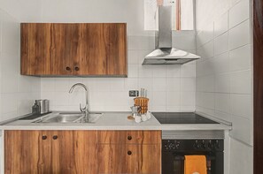 Eine moderne Küche mit Holzschränken, Edelstahlgeräten und einer Spüle mit zwei Becken.