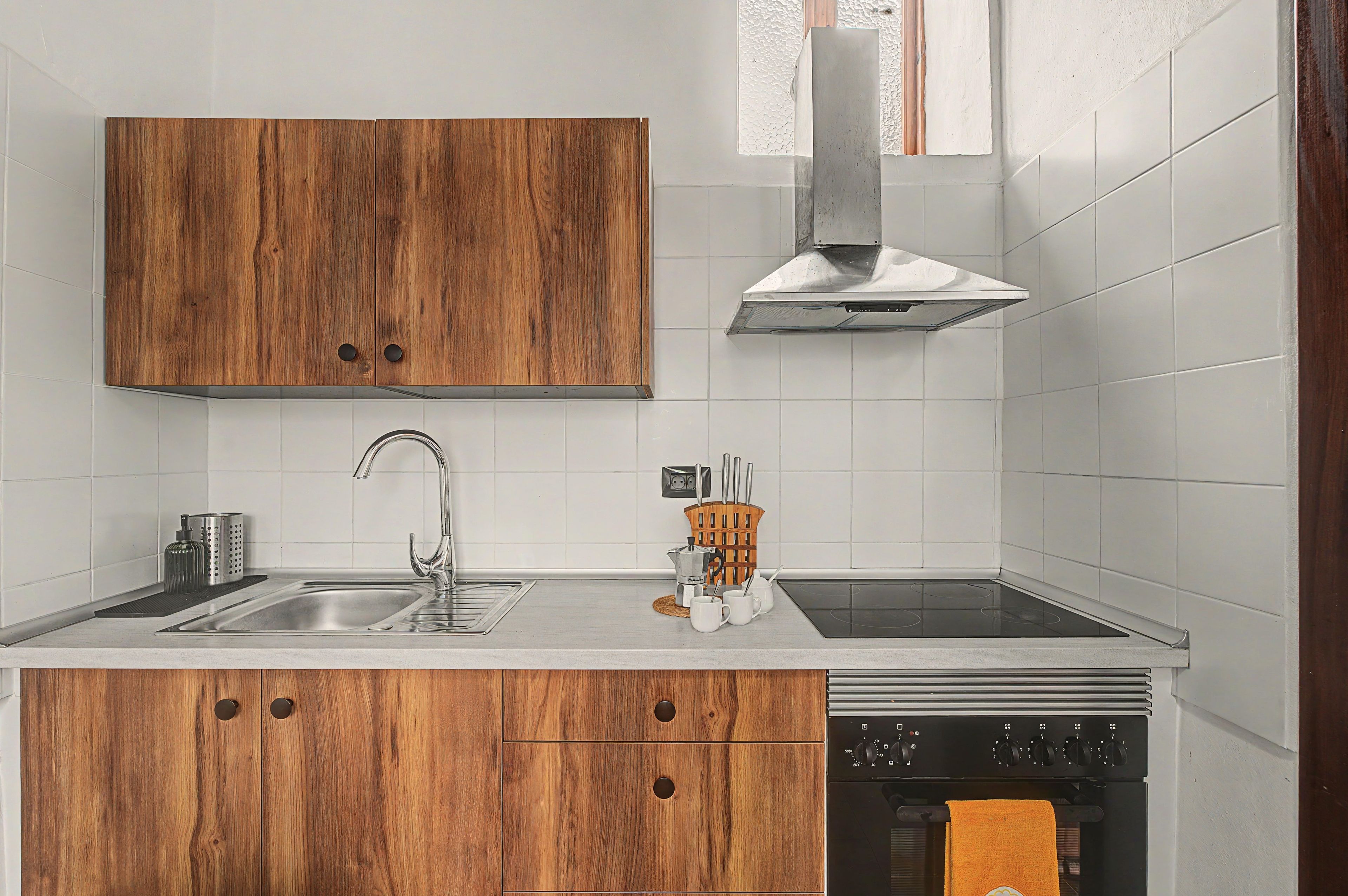 Eine moderne Küche mit Holzschränken, Edelstahlgeräten und einer Spüle mit zwei Becken.