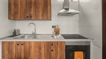 Eine moderne Küche mit Holzschränken, Edelstahlgeräten und einer Spüle mit zwei Becken.