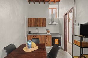 Eine kleine Küche mit Holzausbau, einem Edelstahlspülbecken und einem eingebauten Backofen.