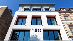 Een modern hotelgebouw met een opvallend bord waarop staat: ‘Mr. Jigs Hotel Venlo.’