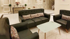 A spacious living area with a sofa set, a coffee table, and a ceiling fan. - Green Forest Hotel (Tebing Tinggi)