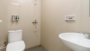 A small, clean bathroom with a toilet, a shower, and a sink. - Green Forest Hotel (Tebing Tinggi)