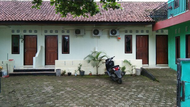 A traditional house with a tiled roof, a motorcycle parked in front, and potted plants. - Pondok Sundawa (Pangandaran)