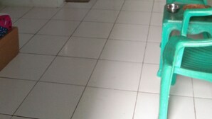 A room with a tiled floor, a radiator, a water dispenser, and two green chairs. - Pondok Sundawa (Pangandaran)