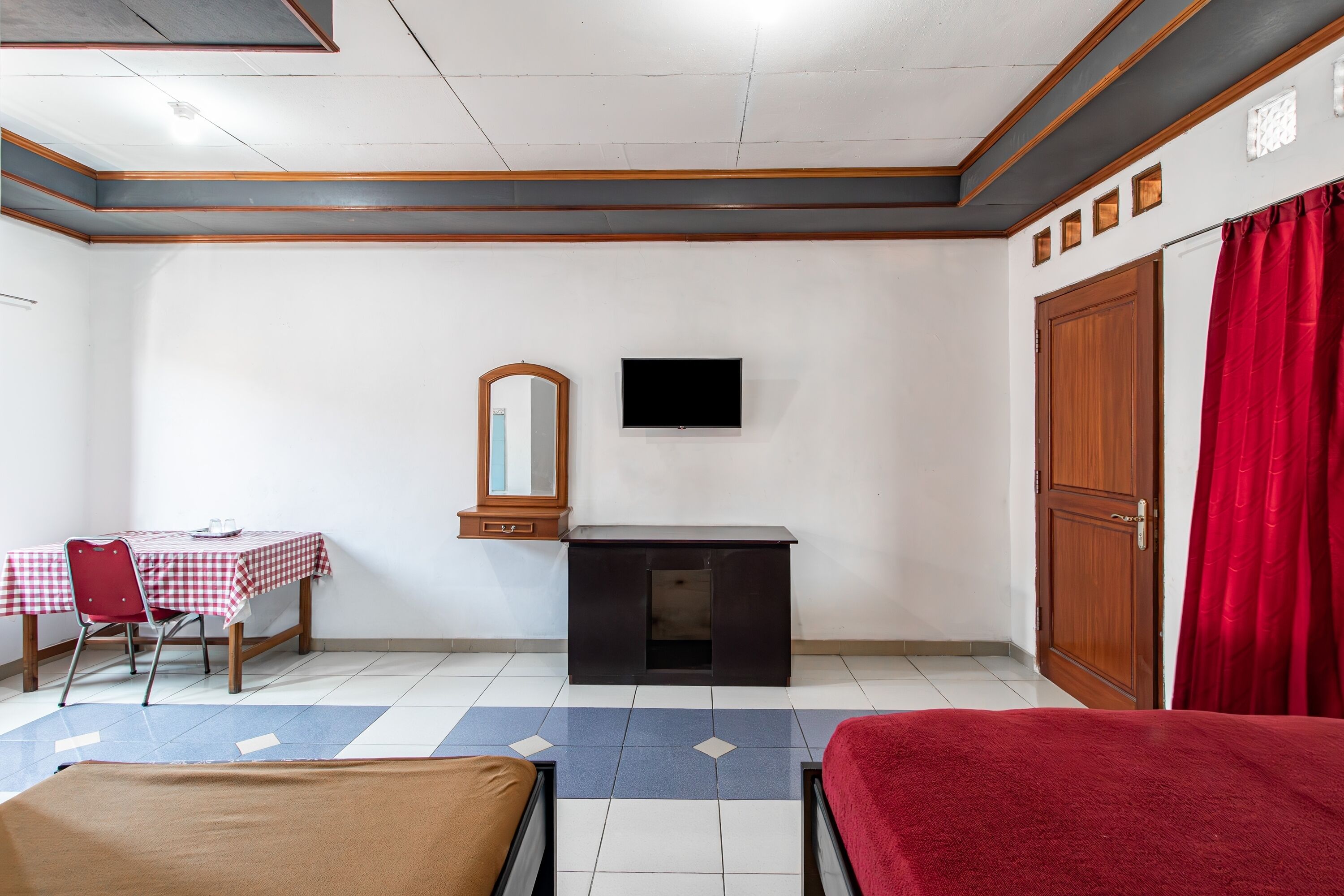 Une chambre comprenant un lit, un bureau avec une chaise, une télévision et une armoire.