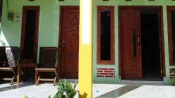 Un edificio con varias puertas de madera y un pilar amarillo.