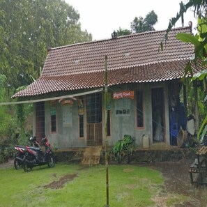 A two-story building with a tiled roof and a signboard. - Penginapan Tasya (Kalirejo)