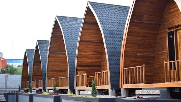 Une rangée de cabanes en bois, dotées de toits à deux versants et de balcons.
