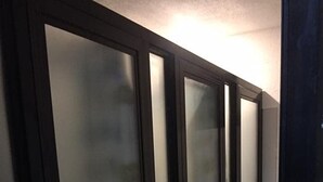 Ein Korridor mit rauen Glastüren und einem Fliesenboden.