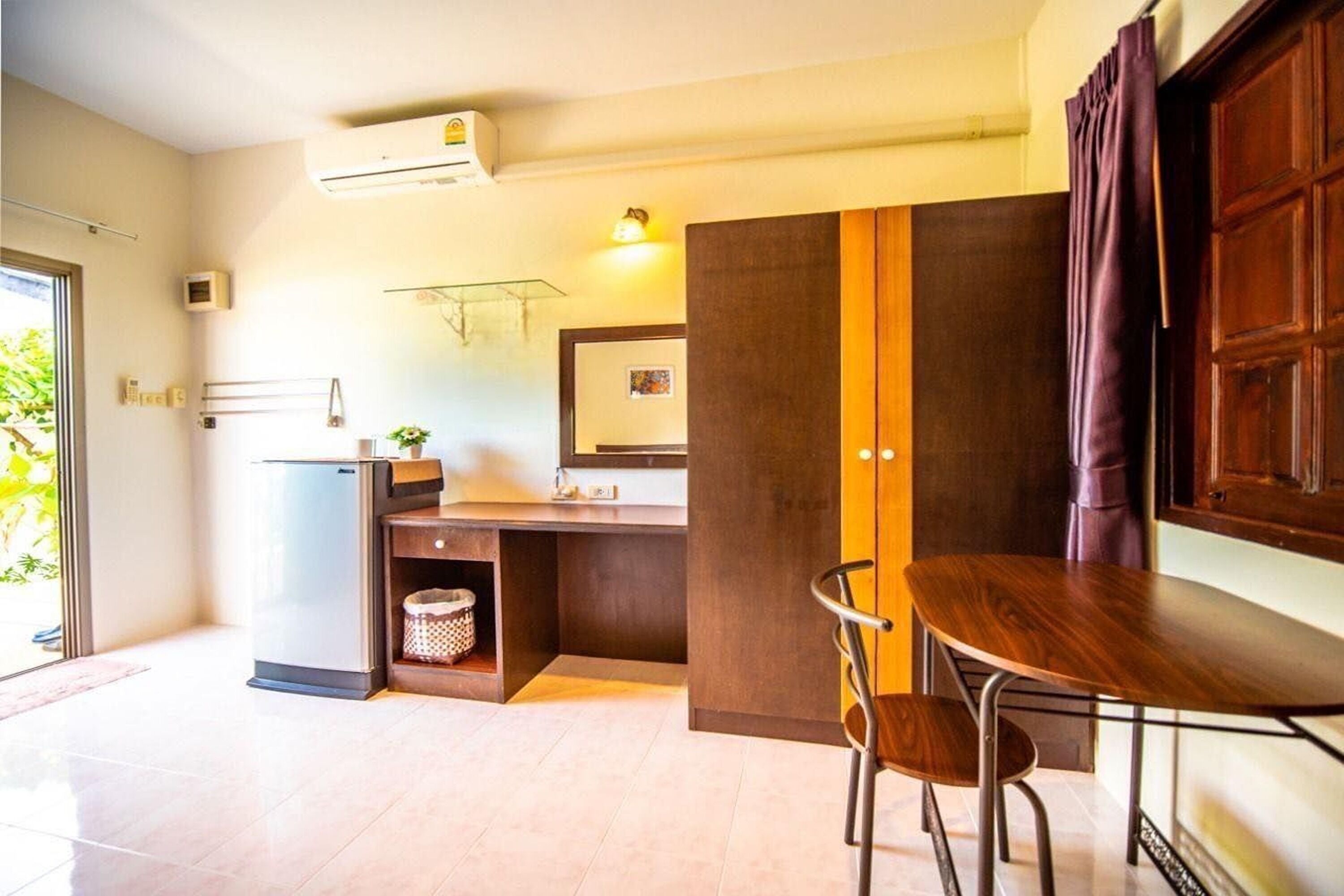 Una cucina moderna con piano cottura integrato, lavello e un bancone. Si nota un tavolo da pranzo in legno con due sedie.