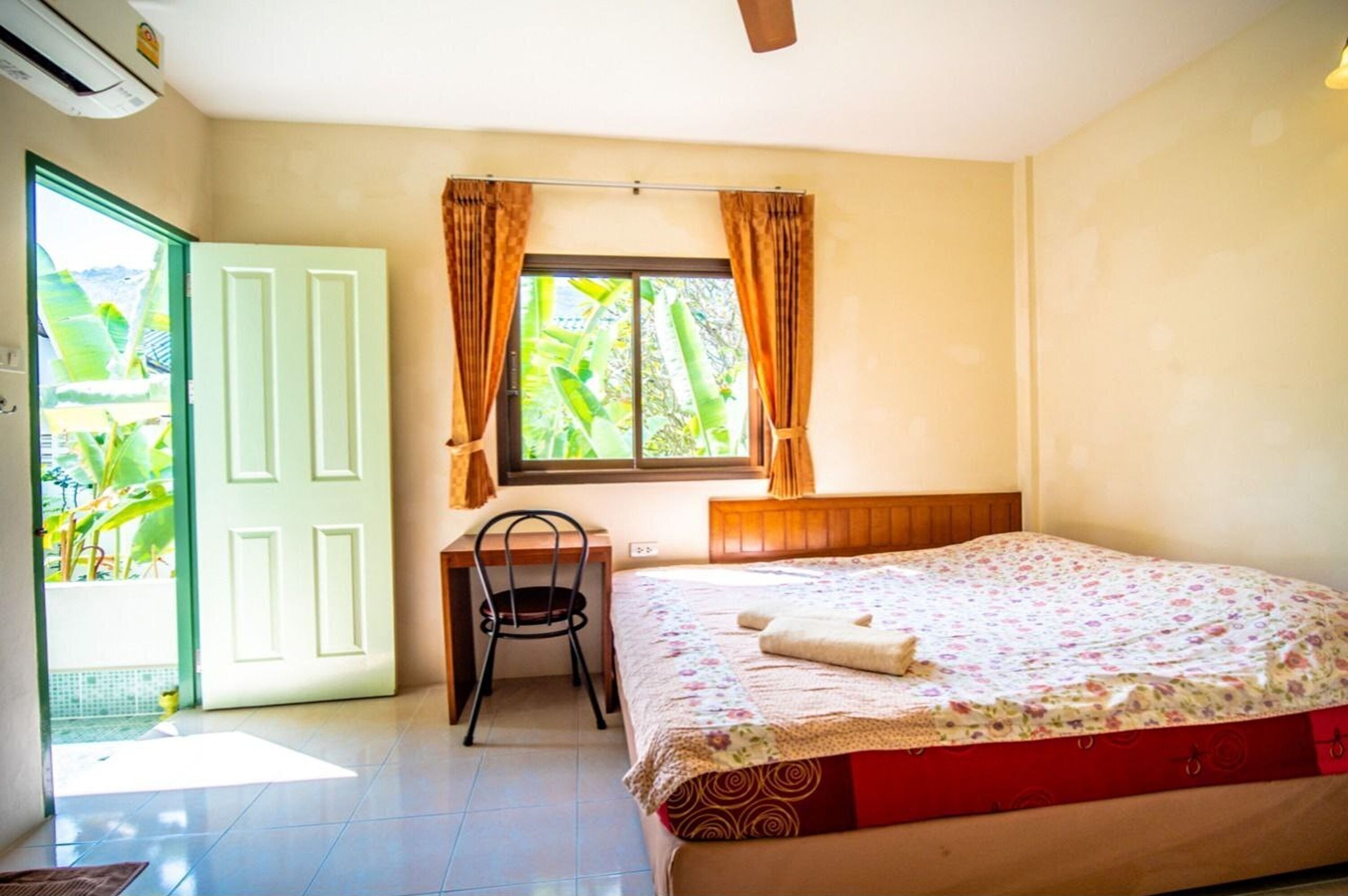 A bedroom with a bed, a desk, and a chair.