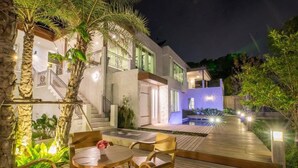A modern house with a wooden deck, a pool, and a staircase leading to the upper floors. - Monkey House (Hang Dong)