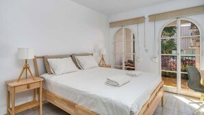 A bedroom with a bed, two bedside tables with lamps, a ceiling fan, and a large arched window with a view of the outdoors. - Panoramic terrace w/pool by Costarentals - Ref 148 (Fuengirola)