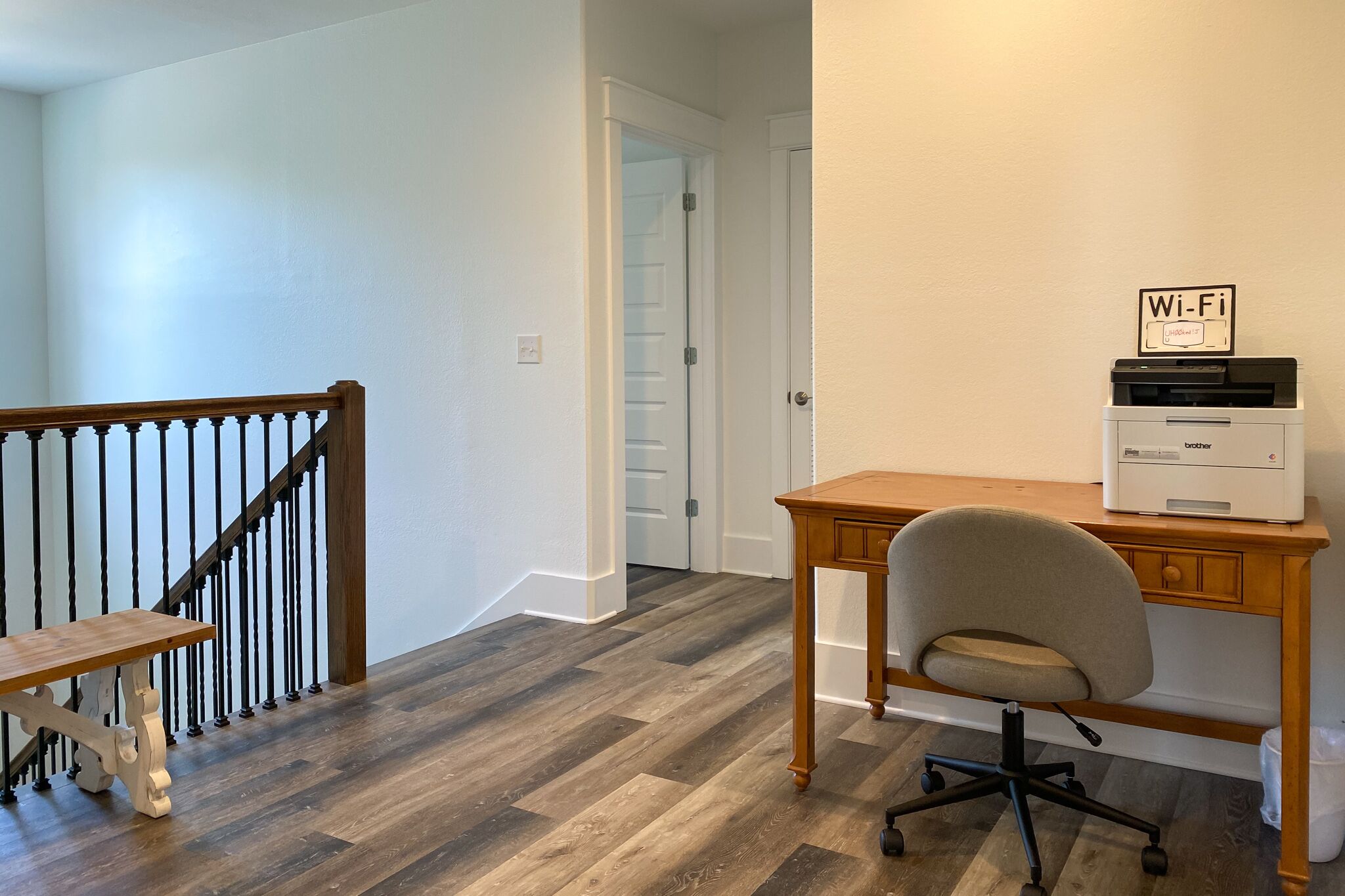 A home office with a desk, chair, and printer.