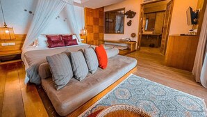 Un dormitorio con cama, sofá, mesita de noche, lámpara, espejo y armario.