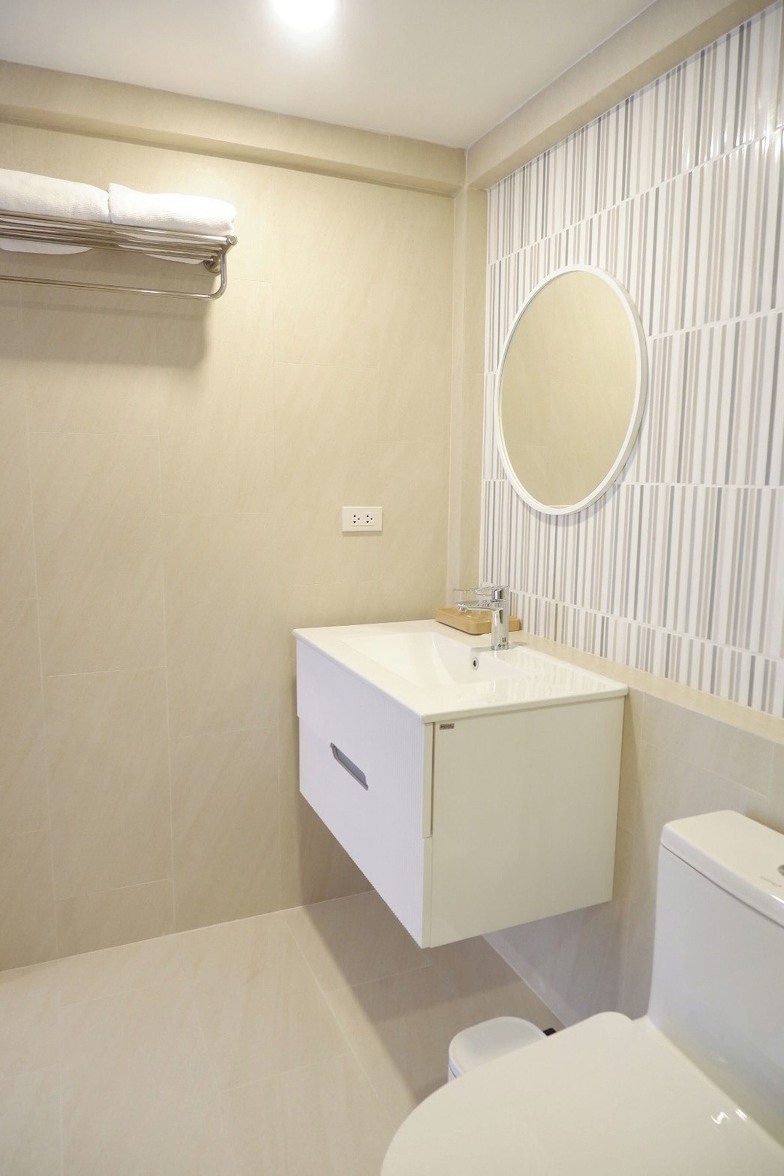 A bathroom with a toilet, a sink, and a mirror.
