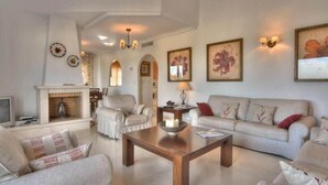 A spacious living room with a fireplace, a sofa set, and a coffee table. - La Manga Club Monte Verde Villa 352 (La Manga Club, Cartagena)
