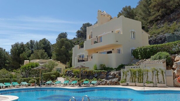 A hotel with a swimming pool, multiple balconies, and lush greenery. - La Manga Club Monte Verde Villa 352 (La Manga Club, Cartagena)