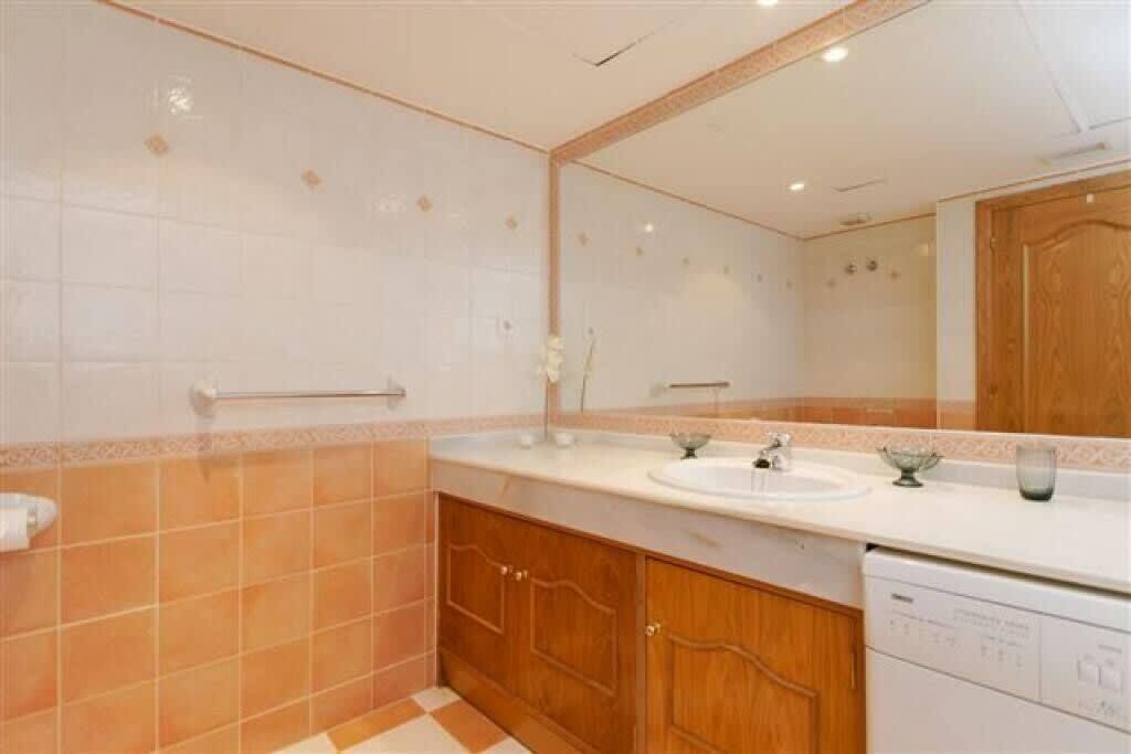Une salle de bain avec deux lavabos, un miroir et un meuble en bois.