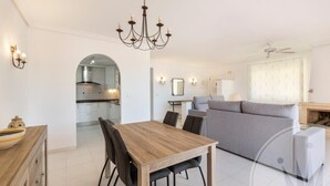 Una sala moderna con una mesa de comedor, sofá y una cocina al fondo.