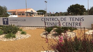 Ingang van een tennisbaan met een bord waarop 