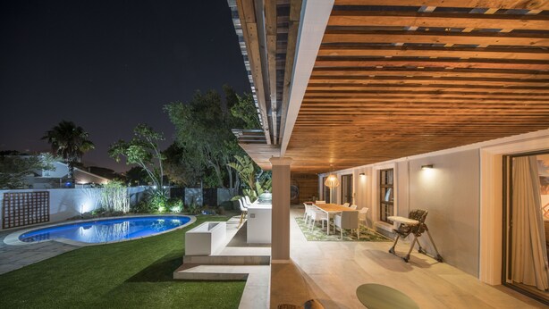 Eine moderne Außenpatio mit Pool, Sitzbereich und Essbereich.