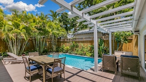 A wooden deck with a pool, surrounded by lush greenery and a wooden fence. - SOUTHERN CROSS ~ Conveniently Located 3 Bedroom, 2.5 Bathroom Gem w/ Pool (Key West)