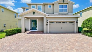 A two-story house with a garage, a front door, and a driveway.